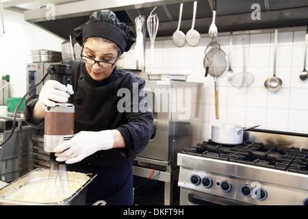 Frau arbeitet im Restaurantküche Stockfoto