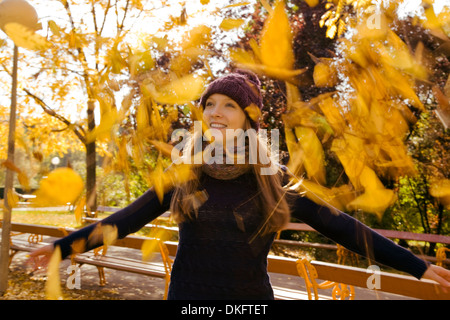 Junge Frau kotzte Herbstlaub im park Stockfoto