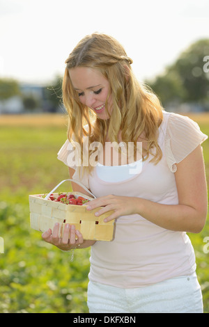 Teenager-Mädchen mit Erdbeeren im Feld Stockfoto