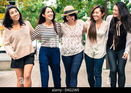 Gruppe von fünf jungen Frauen mit Waffen herum, Lächeln Stockfoto