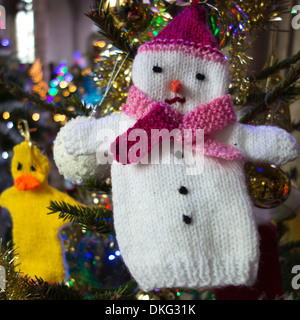 Winter wärmeren: eine gestrickte wollene Schneemann-Handpuppe als Weihnachtsbaum Dekoration verwendet wird. Stockfoto