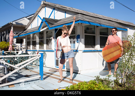 Paar auf Terrasse mit Surfbrettern, Breezy Point, Queens, New York, USA Stockfoto