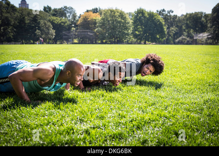 Drei junge Männer, die Push-ups im Park Stockfoto