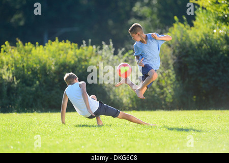 Zwei Jungs im Teenageralter Fußball spielen auf einer Wiese, Oberpfalz, Bayern, Deutschland, Europa Stockfoto