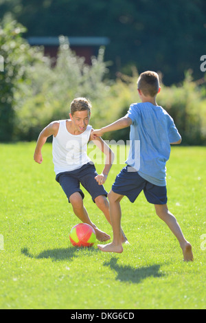 Zwei Jungs im Teenageralter Fußball spielen auf einer Wiese, Oberpfalz, Bayern, Deutschland, Europa Stockfoto