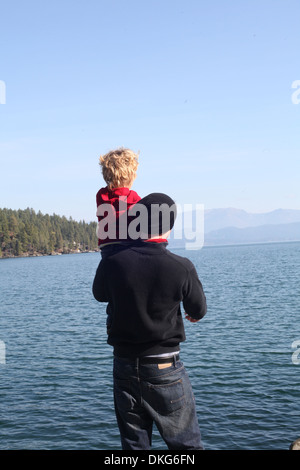 Vater und Kind Tochter betrachten über See Stockfoto