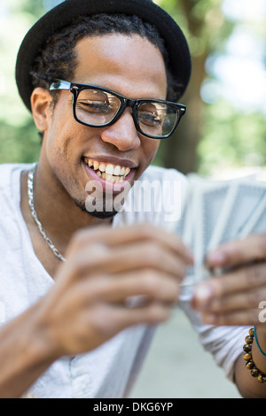 Junger Mann Spielkarten Stockfoto