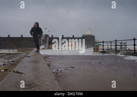 Mann zu Fuß in Sturm am Fort Perch Rock in New Brighton, Wirral, Merseyside, Großbritannien Stockfoto