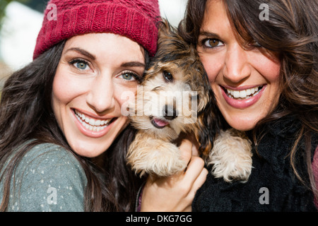 Freunde halten Lieblingshund für Foto Stockfoto