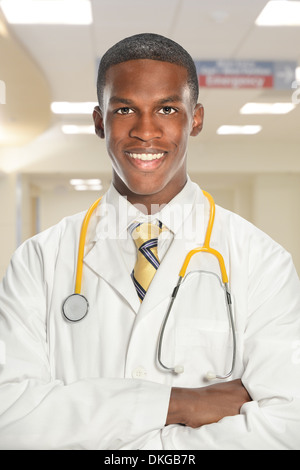Afrikanische amerikanische jungen Arzt mit verschränkten im Krankenhaus Stockfoto