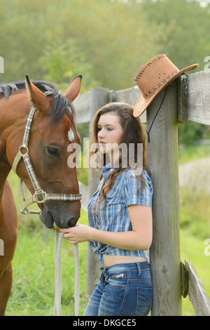 Teenager Mädchen steht mit einem Mecklenburger Pferd auf einer Koppel Stockfoto