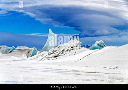 Druck Bergrücken auf dem Meereis mit einer mehrschichtigen linsenförmige Wolke schwebt in der Nähe von Mount Discovery eroberte während der Mission der NASA IceBridge Eis Vermessung 24. November 2013 in der Nähe von Scott Base, Antarktis. Stockfoto