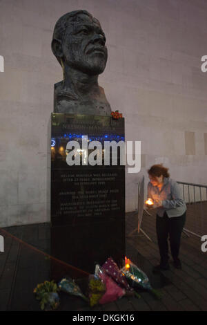 London, UK. 5. Dezember 2013, auf die Nachricht, dass der ehemaligen südafrikanischen Präsidenten und Freiheit Kampf, den Nelson Mandela gestorben war, versammelten sich Londoner spontan an der Nelson Mandela Statue außerhalb der Royal Festival Hall in London Southbank Centre und linken Tribute, Blumen und Kerzen. Foto: Nick Savage/Alamy Live-Nachrichten Stockfoto