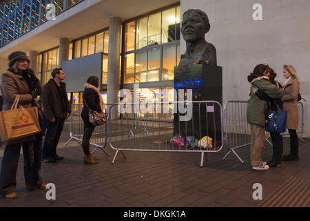 London, UK. 5. Dezember 2013, auf die Nachricht, dass der ehemaligen südafrikanischen Präsidenten und Freiheit Kampf, den Nelson Mandela gestorben war, versammelten sich Londoner spontan an der Nelson Mandela Statue außerhalb der Royal Festival Hall in London Southbank Centre und linken Tribute, Blumen und Kerzen. Foto: Nick Savage/Alamy Live-Nachrichten Stockfoto