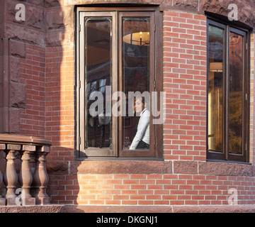 Eine Kellnerin sieht aus dem Fenster in der Newbury Street in Boston. Stockfoto