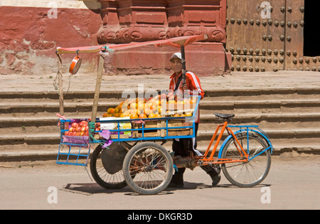 Junger Mann, Verkauf von Orangen aus Fahrrad Pedal Wagen auf der Straße vor der Kirche in Berg Dorf Huancavelica in Peru Stockfoto