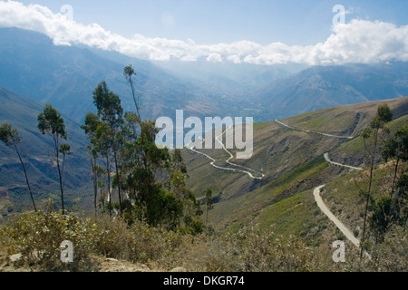 Hohe schmale kurvenreiche Straße durch die Anden in Peru mit Schnee bedeckt Gipfeln, tiefen Tälern und kargen Hügeln überragt Stockfoto