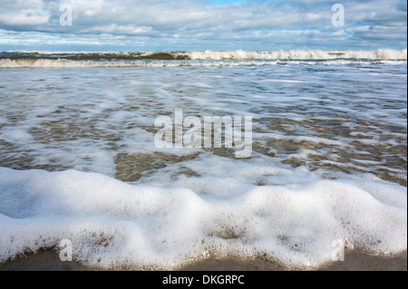 Die Wellen des Ozeans breiten sich dünn, mit Schaum übersät über die Sandküste von Jacksonville Beach, Florida, aus. (USA) Stockfoto
