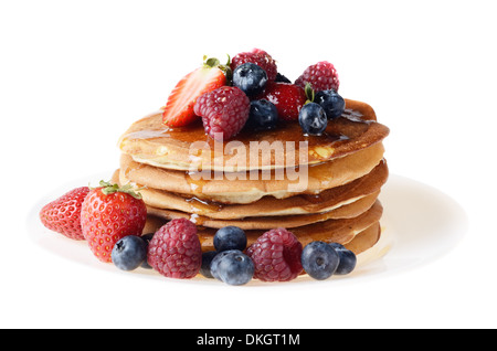 Weißen Teller voll mit Pfannkuchen mit Erdbeeren Himbeeren Heidelbeeren und Honig isoliert auf weiss Stockfoto