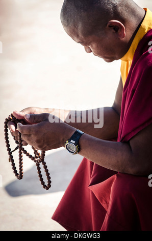 Ein buddhistischer Mönch betet mit einem Satz von Gebetskette (Japa Mala), Bodhnath Stupa Bodhnath, Nepal, Asien Stockfoto