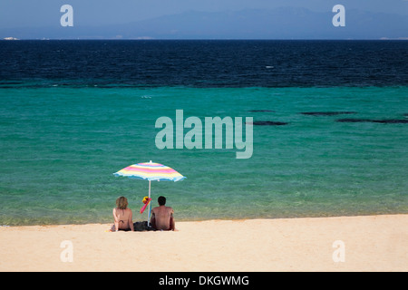 Paar unter einem Sonnenschirm am Strand von Porto Puddu, Sardinien, Italien, Mittelmeer, Europa Stockfoto