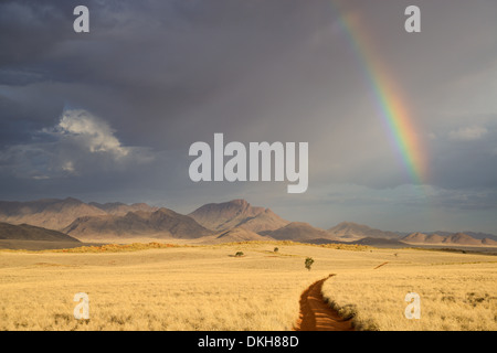 Wolken und Regenbogen am frühen Abend im NamibRand Nature Reserve, Namib-Wüste, Namibia, Afrika Stockfoto