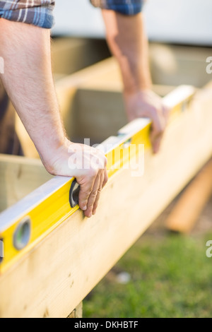 Zimmermanns Hände Überprüfung Ebene aus Holz Stockfoto