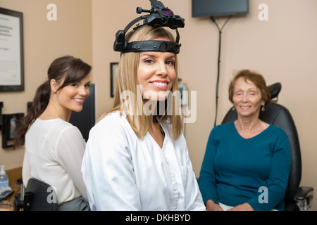 Augenoptiker mit älteren Patienten im Store Stockfoto