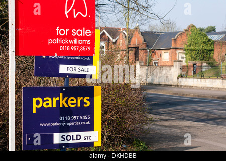 "For Sale" und "Verkauft" Immobilienmakler Anzeichen auf eine Stadt Straße, Reading, Berkshire, England, GB, UK. Stockfoto