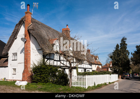 Ferienhaus mit Reetdach in einem englischen Landhaus-Dorf. Das Ferienhaus verfügt über eine TV-Antenne und eine Satellitenschüssel. Stockfoto