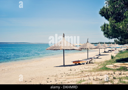 Sonnenstrand mit Stroh Sonnenschirm, Insel Pag, Kroatien, Europa Stockfoto