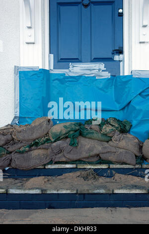 Cley Norfolk, Großbritannien. 6. Dezember 2013. Sandsäcken und Plastikplanen in zur Verhinderung von Hochwasserschäden an Rhe Haustür von einem Ferienhaus in Cley Norfolk, wo Storm Surge Gewässer Küstenschutzes verletzt und verursacht schweren Überschwemmungen in den größten Gezeiten in 60 Jahren gesehen. 6. Dezember 2013 Credit: Tim James/The Gray Gallery/Alamy Live-Nachrichten Stockfoto