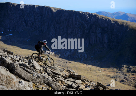 Ein Mountainbiker reitet den Rangers Weg vom Gipfel des Snowdon in Snowdonia-Nationalpark Stockfoto