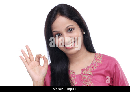 Junge Inderin zeigt "OK" Zeichen vor weißem Hintergrund Stockfoto