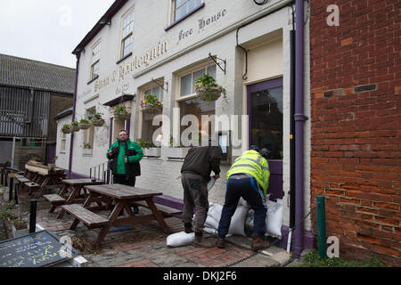 Faversham, Kent, UK. 6. Dezember 2013. Einheimischen Stapel Sandsäcke zum Schutz des Swan und Harlekin Pub im Quay Lane. Eine Flutwelle gepaart mit hohen Gezeiten verbreitet Überschwemmungen verursacht. Bildnachweis: Christopher Briggs/Alamy Live-Nachrichten Stockfoto