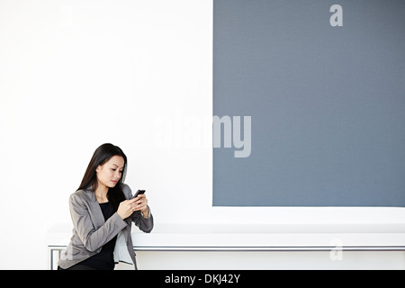 Geschäftsfrau mit Handy im Büro Stockfoto