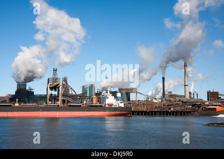 Großes Schiff vor einem großen Stahlfabrik in IJmuiden, Niederlande Stockfoto