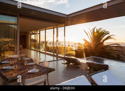 Terrasse mit Blick auf Pool und Meer bei Sonnenuntergang Stockfoto