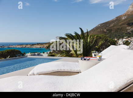 Liegestühlen und Pool mit Blick auf Meer Stockfoto