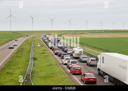 Lelystad - 17. August: Verkehr bewegt sich langsam entlang einer befahrenen Highway entlang einem Deich und Windkraftanlagen am 17. August 2012 in Lelystad, t Stockfoto