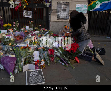 London, UK. 6. Dezember 2013. Leute zahlen Hinsicht und bieten floral Tribute bei der Mahnwache für Nelson Mandelas außerhalb South Africa House, Trafalgar Sq., London, UK-Credit: Julio Etchart/Alamy Live News Stockfoto