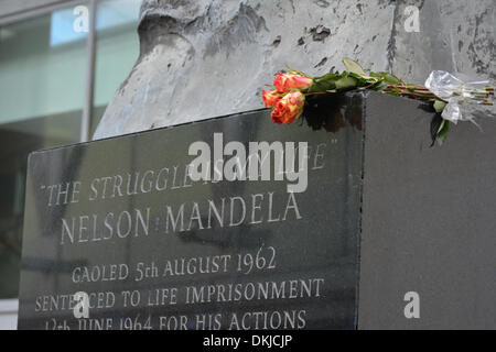 London, UK. 6. Dezember 2013. Trauernde lassen Sie Blumen auf Nelson Mandela Statue auf der South Bank, London. Nelson Mandela, starb am 5. Dezember 2013 nach einem langen Kampf mit seiner Gesundheit erster schwarzer Präsident Südafrikas. Bildnachweis: Patricia Phillips/Alamy Live-Nachrichten Stockfoto