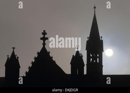 Magdeburg, Deutschland. 3. Dezember 2013. Die Sonne scheint durch eine dicke Schicht von Wolken hinter die Silhouette Türme der Kathedrale in Magdeburg, Deutschland, 3. Dezember 2013. Foto: Jens Wolf/ZB/Dpa/Alamy Live News Stockfoto