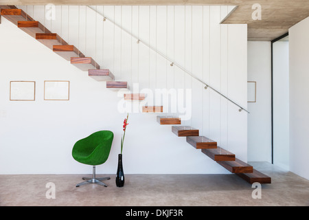 Stuhl unter schwebende Treppe in modernes Haus Stockfoto