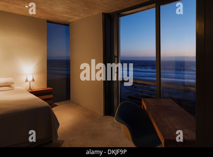 Moderne Schlafzimmer mit Blick auf Meer in der Abenddämmerung Stockfoto