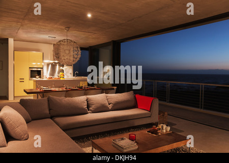 Sofa und Esstisch im modernen Wohnzimmer mit Blick auf Meer Stockfoto