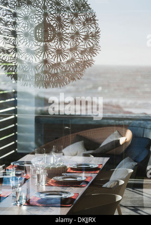 Gedeckter Tisch im modernen Speisesaal mit Blick auf Meer Stockfoto