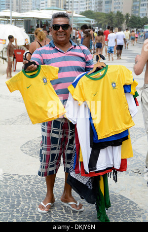 Eine Straße Hawker mit einem Arm des brasilianischen Fußball-Shirts zum Verkauf an der Copacabana in Rio De Janeiro, Brasilien Stockfoto