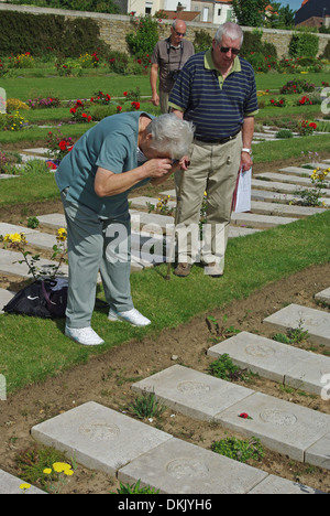 Ältere Dame, die ein Foto von einem Verwandten das Grab in WW1 Friedhof von Boulogne East Stockfoto