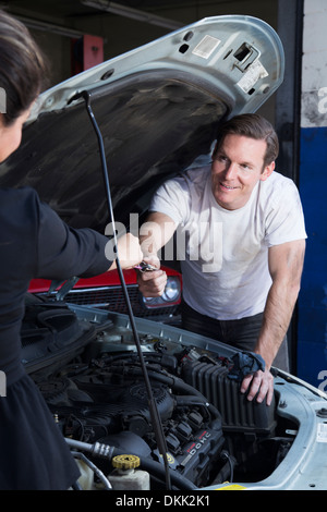 Männliche Mechaniker unter der Motorhaube eines Autos Stockfoto